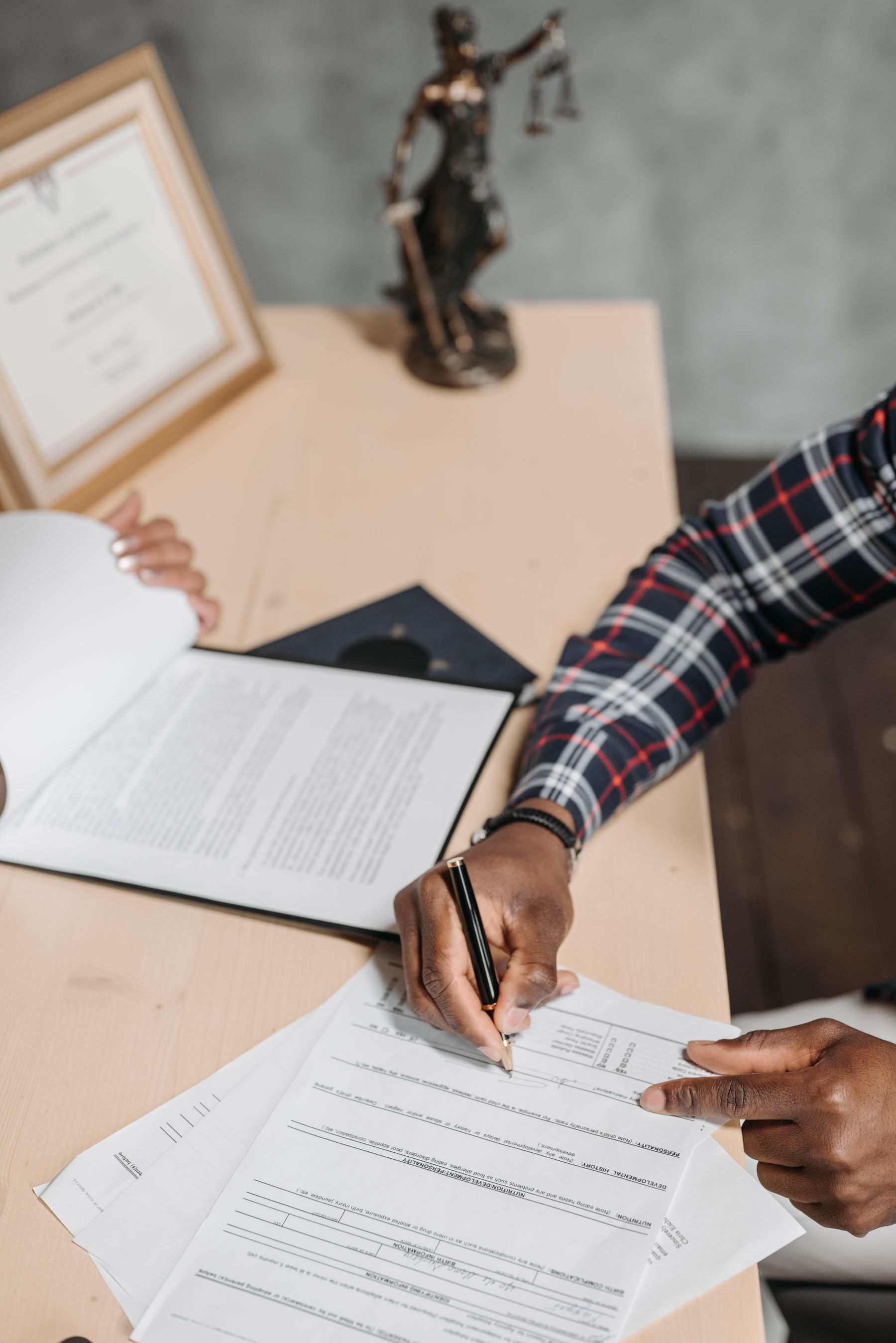A professional signing and reviewing documents at a desk
