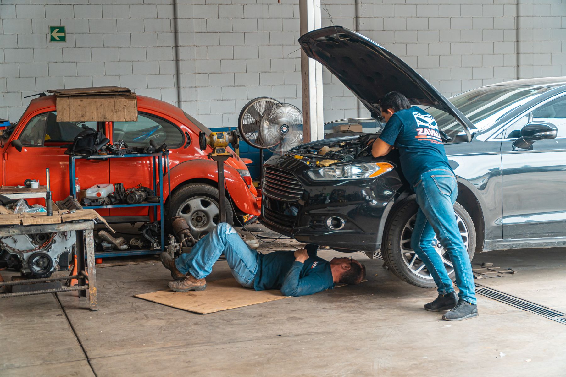 Mechanics repairing a vehicle in a workshop