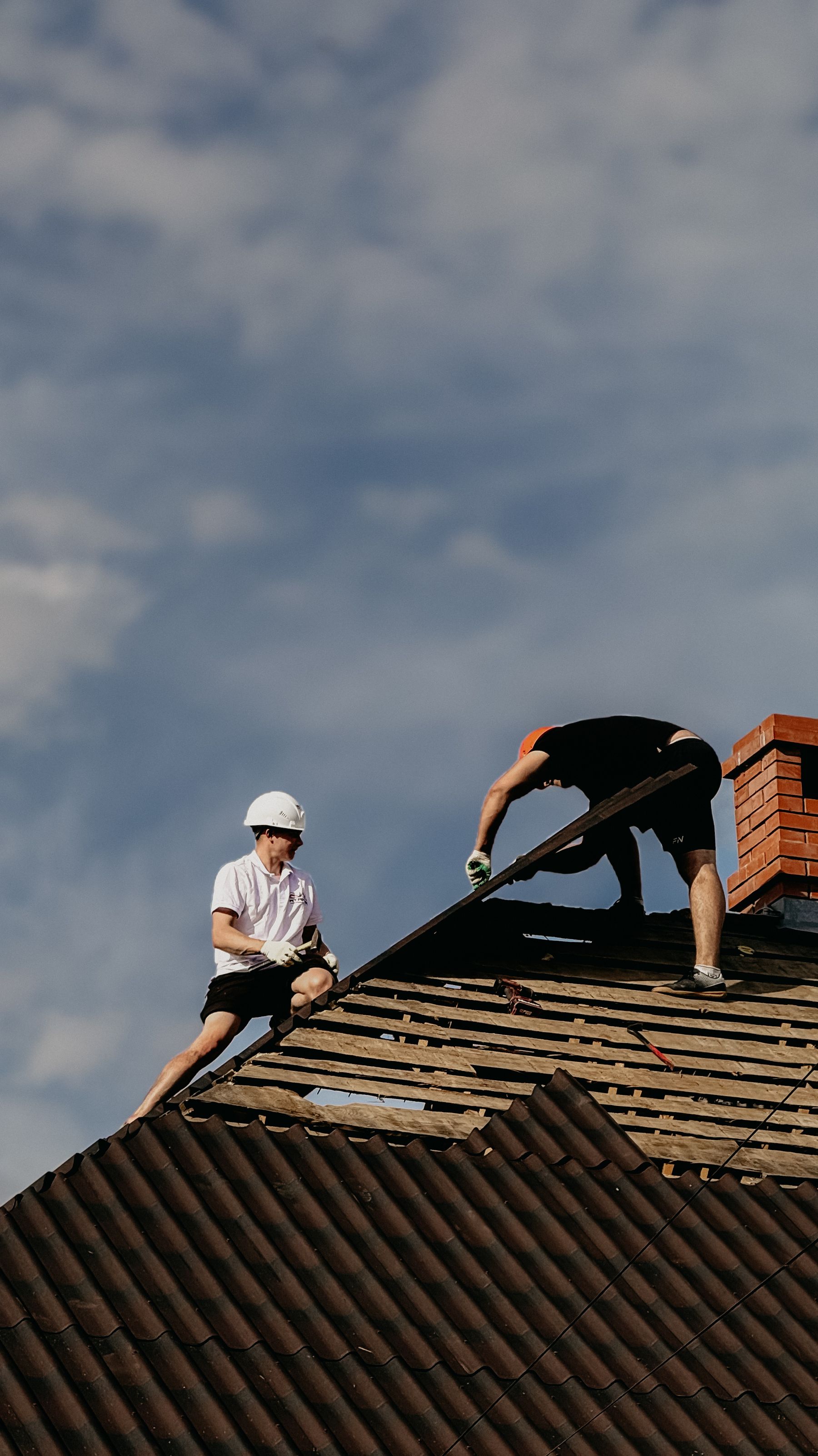 Roofing professionals repairing a residential roof